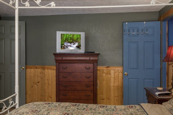 Flat-screen television and dresser in a bedroom at Breezy Mountain Lodge, an 11-bedroom cabin rental located in Pigeon Forge