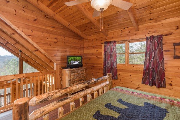 Bedroom with open loft, large windows, and TV at Leconte View Lodge, a 3 bedroom cabin rental located in Pigeon Forge