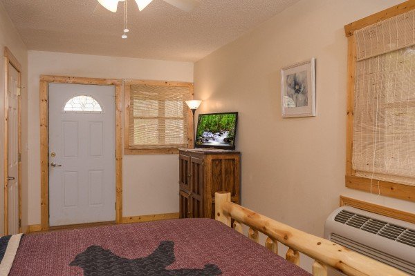 Bedroom with a TV, armoire, and deck access at Leconte View Lodge, a 3 bedroom cabin rental located in Pigeon Forge