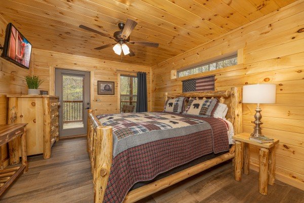 Bedroom with dresser, TV, and deck access at Poolin Around, a 2 bedroom cabin rental located in Gatlinburg