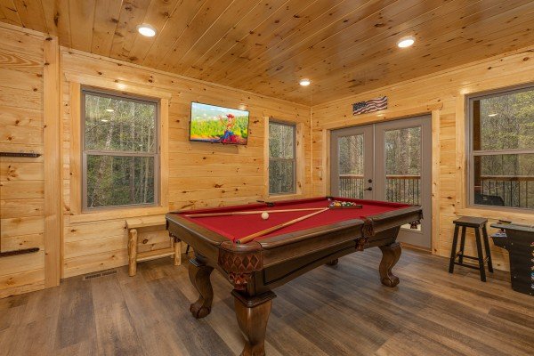 Pool table and TV in a game room at Poolin Around, a 2 bedroom cabin rental located in Gatlinburg