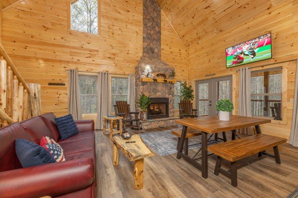 Living room and dining space with fireplace and TV at Poolin Around, a 2 bedroom cabin rental located in Gatlinburg