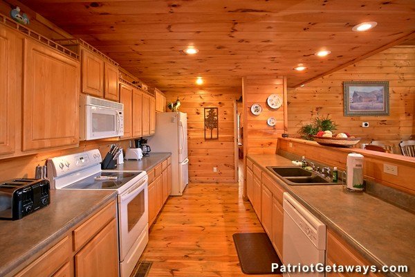 Kitchen with white appliances at Pot O' Gold, a 4 bedroom cabin rental located in Pigeon Forge