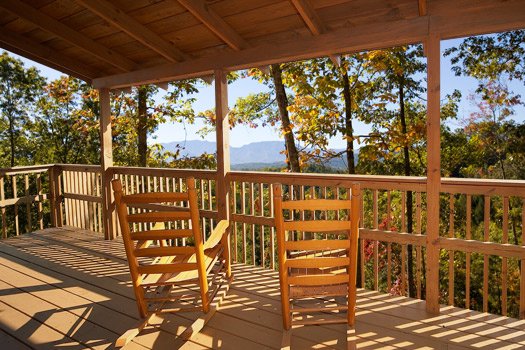 Deck with rocking chairs and view of the Smoky Mountains at Mountain Magic, a 1 bedroom cabin rental located in Pigeon Forge