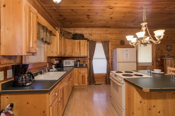 Kitchen with white appliances at Mountain Magic, a 1 bedroom cabin rental located in Pigeon Forge