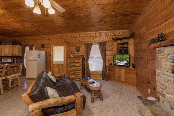 Futon in the living room at Mountain Magic, a 1 bedroom cabin rental located in Pigeon Forge