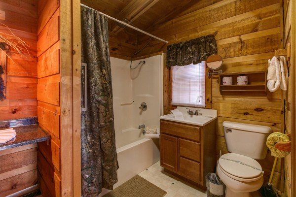 Bathroom with a tub and shower at Beary Good Time, a 1-bedroom cabin rental located in Pigeon Forge