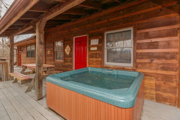 Hot tub on a covered deck at Beary Good Time, a 1-bedroom cabin rental located in Pigeon Forge