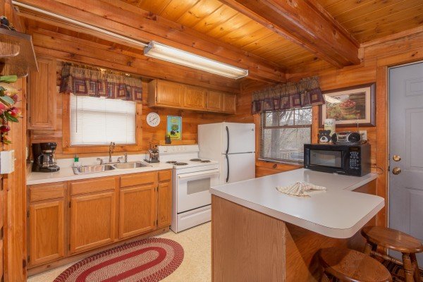 Kitchen with white appliances at Beary Good Time, a 1-bedroom cabin rental located in Pigeon Forge