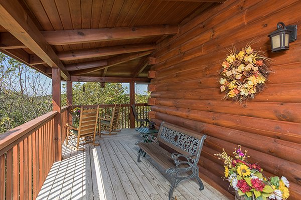 Bench and rocking chairs on the covered deck at Lake Life, a 4 bedroom cabin rental located in Sevierville