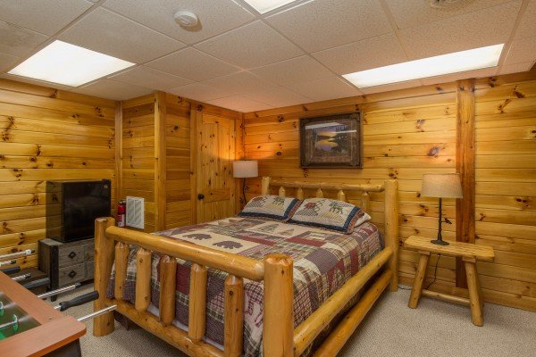 Bedroom with a log bed, night stands, and lamps at Kelly's Cabin, a 1 bedroom cabin rental located in Pigeon Forge