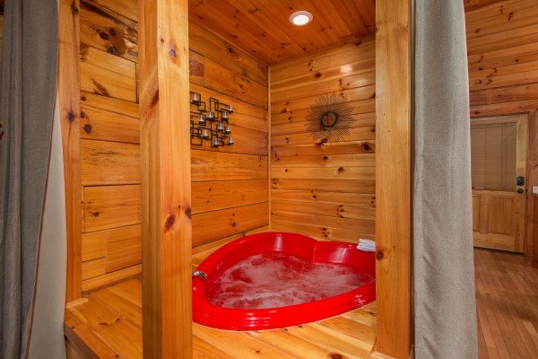 A heart shaped jacuzzi tub at Kelly's Cabin, a 1 bedroom cabin rental located in Pigeon Forge