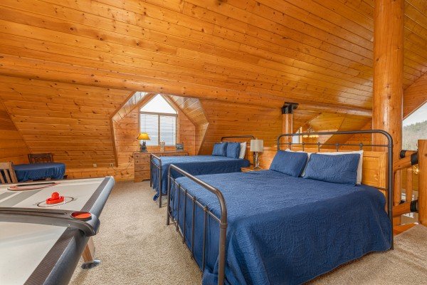 Two queen beds and an air hockey table in the loft at Smoky Mountain Escape, a 3 bedroom cabin rental located in Pigeon Forge