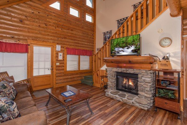 Living room with fireplace and TV at Starry Starry Night #725, a 2 bedroom cabin rental located in Pigeon Forge