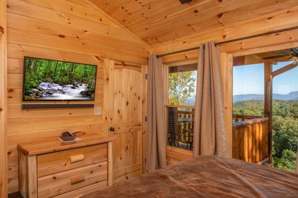 TV and dresser in a bedroom at Panorama, a 2 bedroom cabin rental located in Pigeon Forge