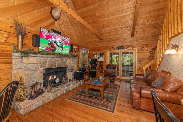 Living room with fireplace, TV, sofa, and arcade at Whispering Pines, a 2 bedroom cabin rental located in Pigeon Forge