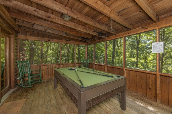 Pool table on a screened porch at Whispering Pines, a 2 bedroom cabin rental located in Pigeon Forge