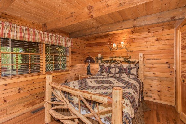 Queen log bed at Whispering Pines, a 2 bedroom cabin rental located in Pigeon Forge