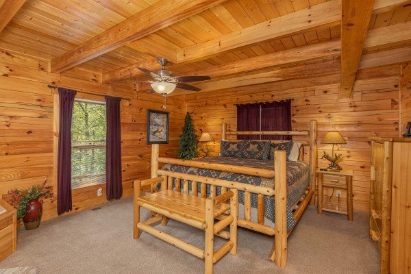Bedroom with a log bed, night stands, lamps, and bench at Smokies Paradise Lodge, a 5 bedroom cabin rental located in Pigeon Forge