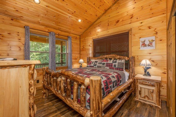 Master bedroom with log king-sized bed at 2 Crazy Cubs, a 2 bedroom cabin rental located in Pigeon Forge