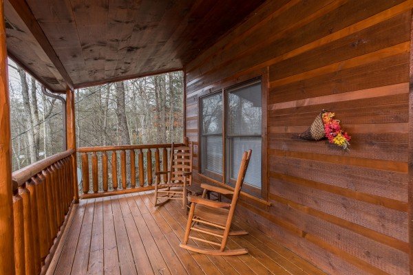 Rocking chairs on a covered deck at Just Relax, a 2 bedroom cabin rental located in Pigeon Forge