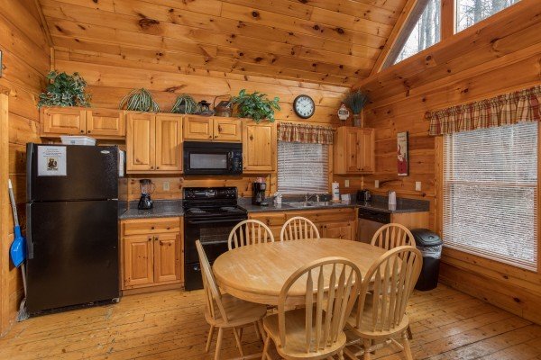 Kitchen with black appliances and dining space for 6 at Just Relax, a 2 bedroom cabin rental located in Pigeon Forge