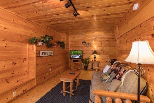 Futon and TV in the game room at Just Relax, a 2 bedroom cabin rental located in Pigeon Forge