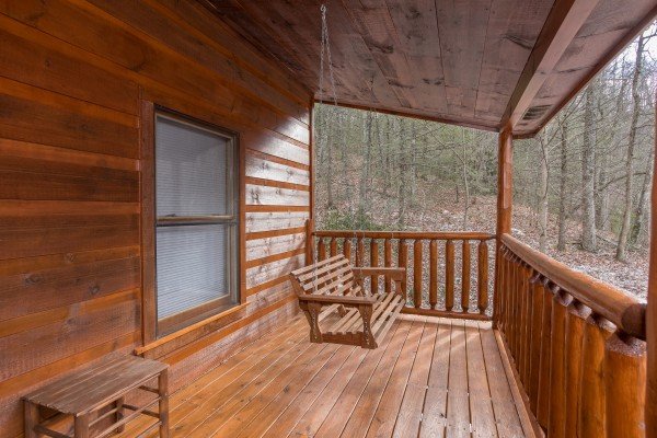 Swing on a covered deck at Just Relax, a 2 bedroom cabin rental located in Pigeon Forge