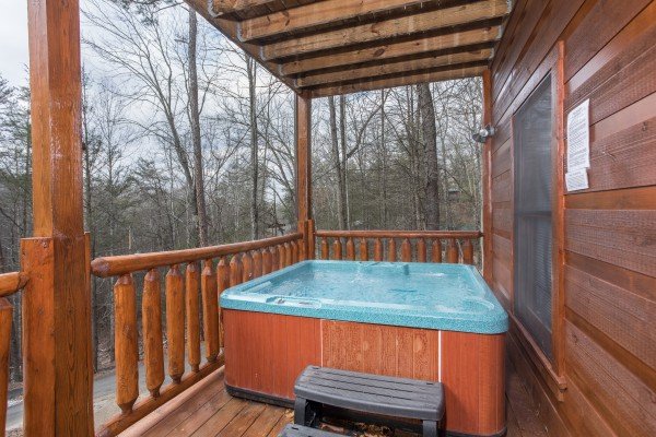 Hot tub on a covered deck at Just Relax, a 2 bedroom cabin rental located in Pigeon Forge