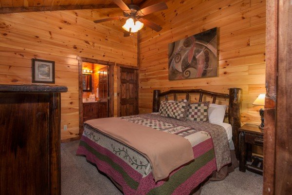 Bedroom with a king bed, night stand, and lamp at Tennessee Treasure, a 3 bedroom cabin rental located in Pigeon Forge