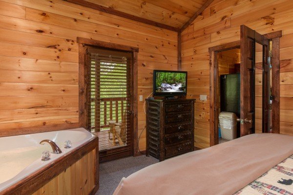 Dresser, TV, and jacuzzi in a bedroom at Tennessee Treasure, a 3 bedroom cabin rental located in Pigeon Forge