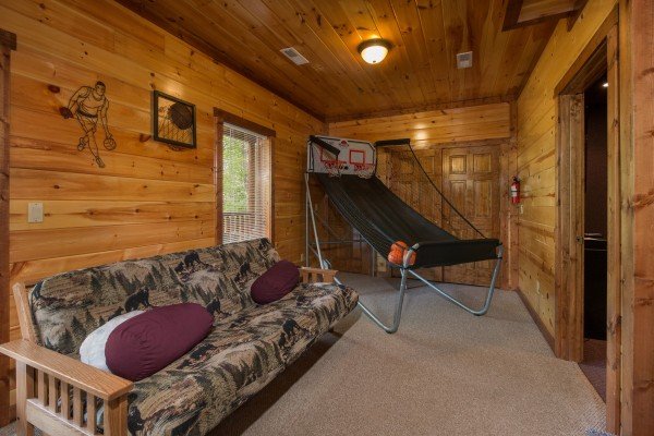 Futon and basketball game in the game room at Tennessee Treasure, a 3 bedroom cabin rental located in Pigeon Forge