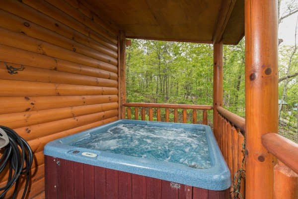 Hot tub on a covered deck at Tennessee Treasure, a 3 bedroom cabin rental located in Pigeon Forge