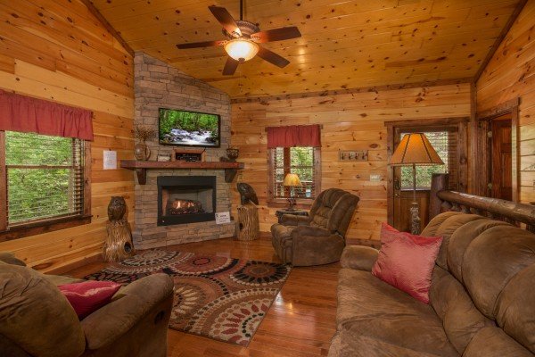 Living room with fireplace and tv at Tennessee Treasure, a 3 bedroom cabin rental located in Pigeon Forge