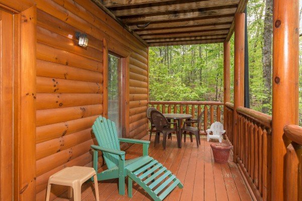 Chairs and a dining table on a covered deck at Tennessee Treasure, a 3 bedroom cabin rental located in Pigeon Forge