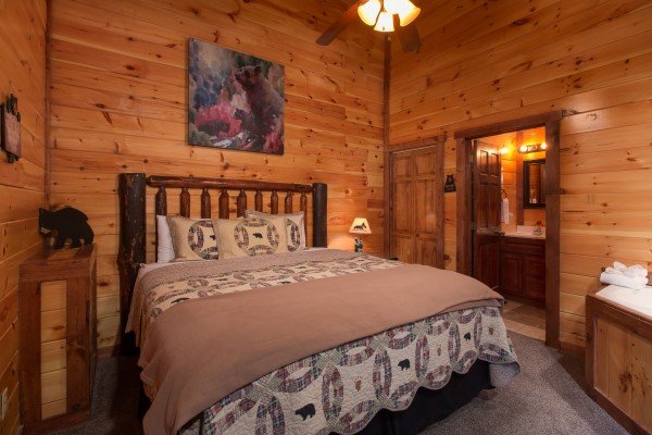 Bedroom with a log bed, night stand, and lamp at Tennessee Treasure, a 3 bedroom cabin rental located in Pigeon Forge