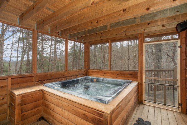 Hot tub on a screened porch at Sweet Mountain Escape, a 2 bedroom cabin rental located in Pigeon Forge