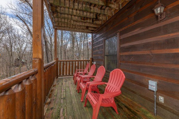 Red Adirondack chairs on the lower deck at Dragonfly, a 2 bedroom cabin rental located in Gatlinburg