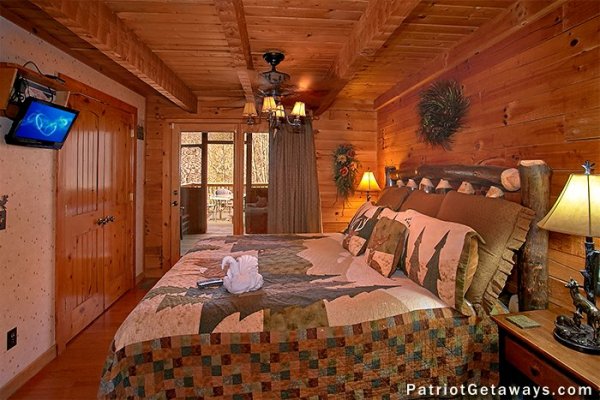 Bedroom with a king bed, television, and deck access at Stags Leap, a 2 bedroom cabin rental located in Pigeon Forge