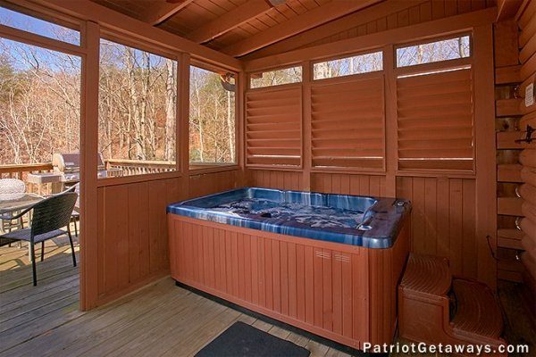 Hot tub on a covered deck with privacy fence at Stags Leap, a 2 bedroom cabin rental located in Pigeon Forge