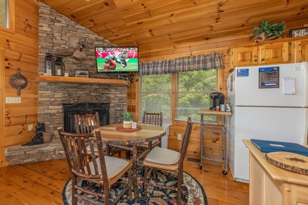 Dining space near a fireplace at Honeysuckle Hideaway, a 1 bedroom cabin rental located in Pigeon Forge