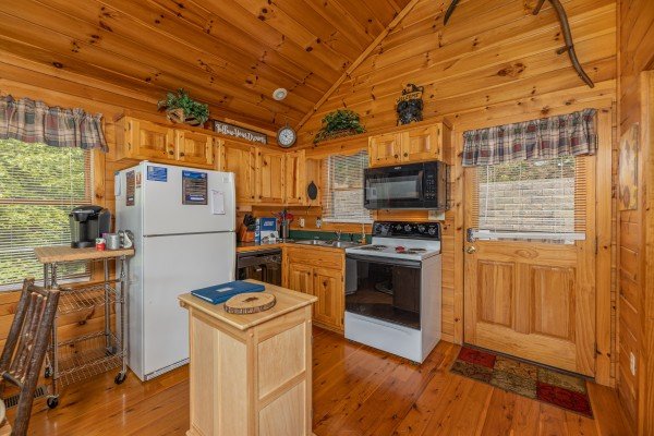 Kitchen with white appliances at Honeysuckle Hideaway, a 1 bedroom cabin rental located in Pigeon Forge