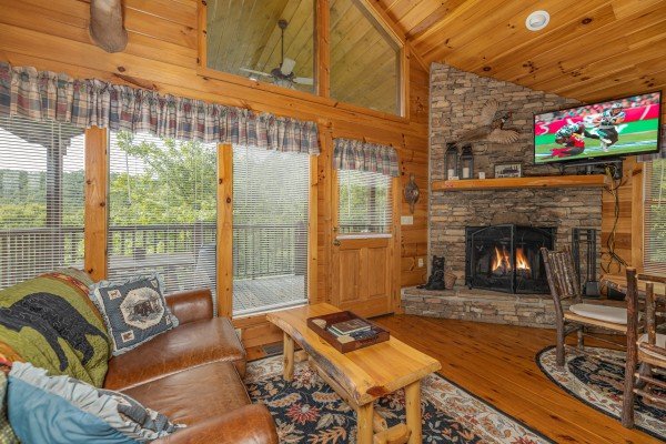 Fireplace and TV in a living room at Honeysuckle Hideaway, a 1 bedroom cabin rental located in Pigeon Forge