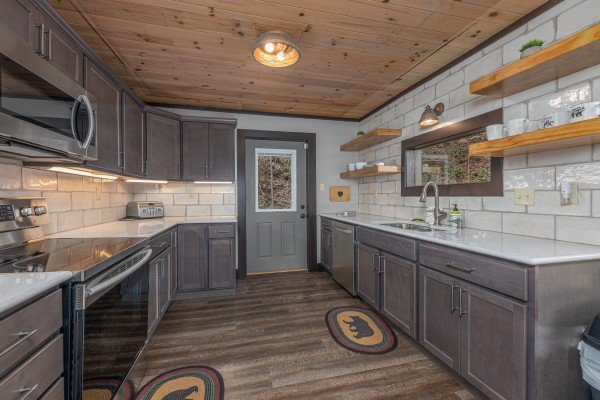 Kitchen with stainless appliances and a door to the deck at Ober the Top Views, a 3 bedroom cabin rental located in Gatlinburg