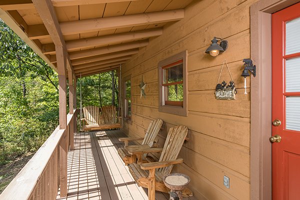 Adirondack chairs and porch swing at the entry bearfoot adventure a 2 bedroom cabin rental located in gatlinburg
