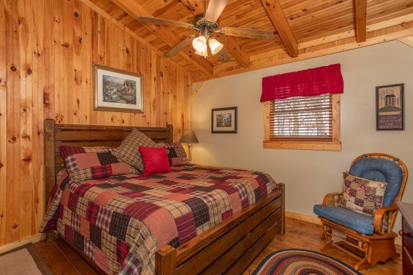 Loft bedroom with a king bed and glider at Bearfoot Adventure, a Gatlinburg Cabin rental