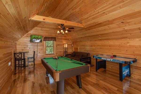 Pool table, air hockey, and a TV in the game loft at Momma Bear, a 2 bedroom cabin rental located in Pigeon Forge