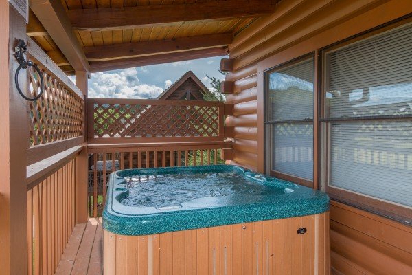 Hot tub on a covered porch at Momma Bear, a 2 bedroom cabin rental located in Pigeon Forge