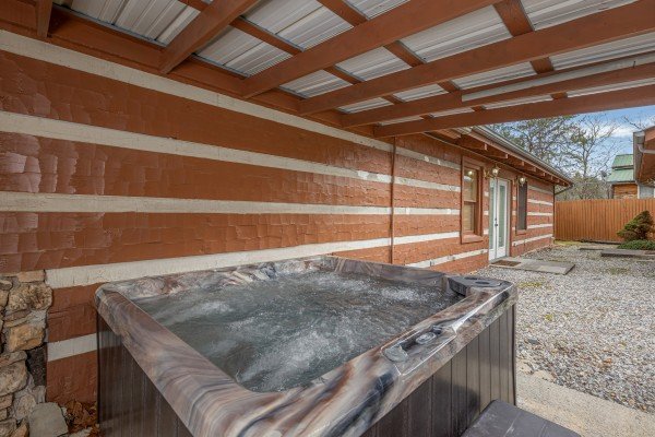 Hot tub on a covered patio at Rustic Ranch, a 2 bedroom cabin rental located in Pigeon Forge