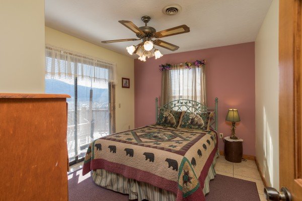 Bedroom with night stand, lamp, and deck access at Alone at the Top, a 3 bedroom cabin rental located in Pigeon Forge